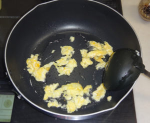 フッ素コートのフライパンを使って卵を油を混ぜている様子